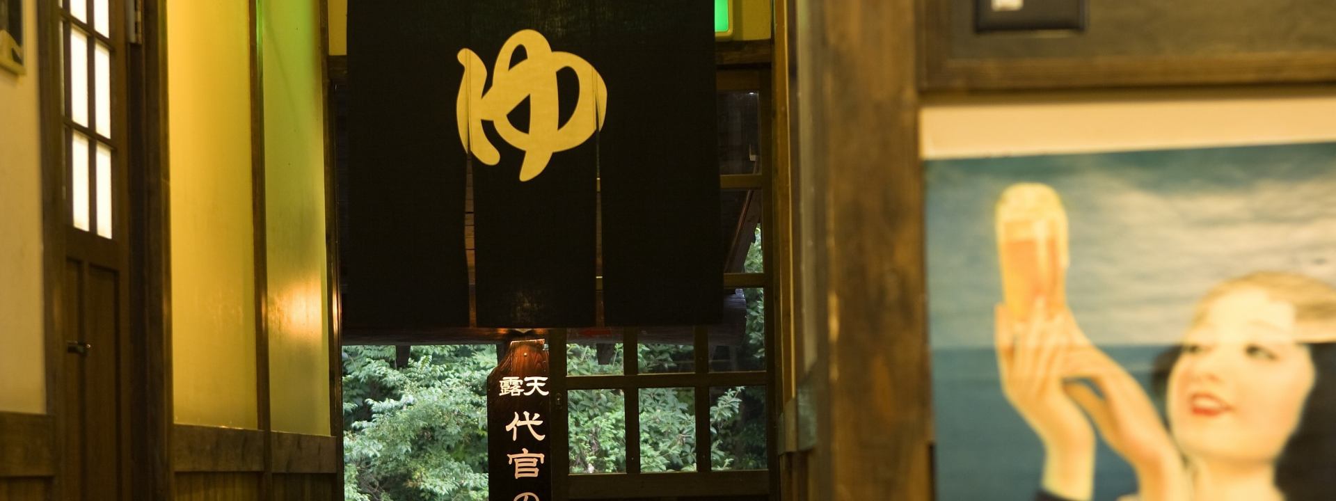 御客屋の湯処入口 — 「ゆ」の暖簾と「露天 代官の湯」の木札