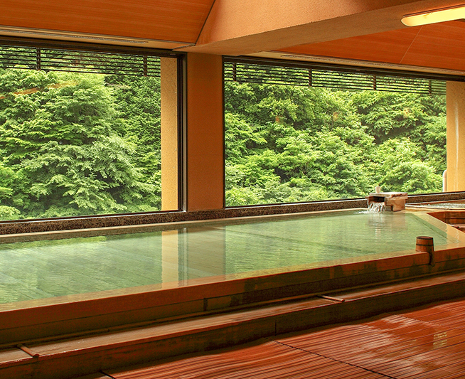 西山温泉 慶雲館 — 渓谷の新緑を望む内湯「日の香」 · 全客室の蛇口・浴槽が自家源泉100%掛け流し