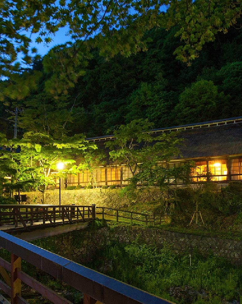 大沢温泉 山水閣 — 花巻・豊沢川岸 · 茅葺き屋根の菊水館と木造湯治屋が並ぶ夜景