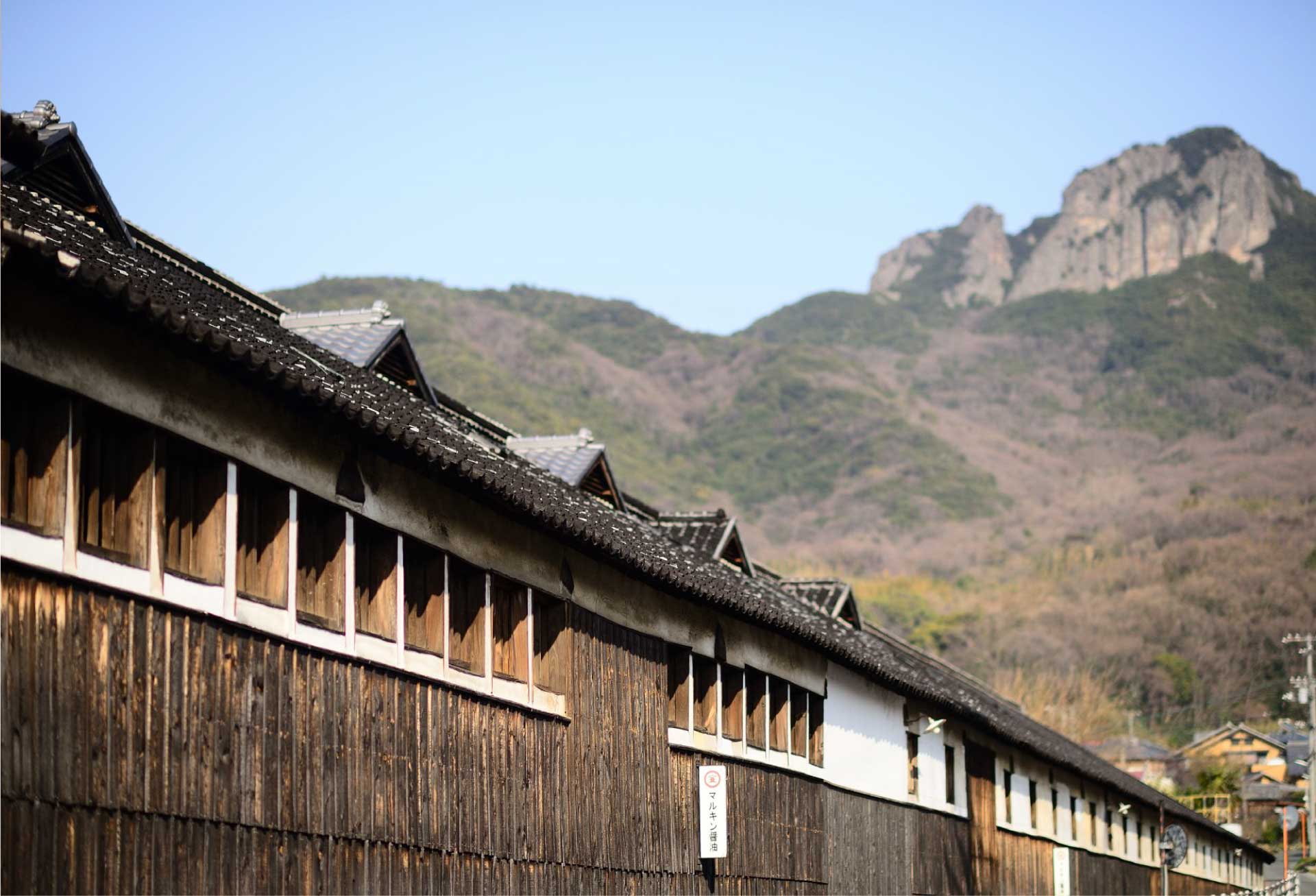島宿 真里 — 苗羽・醤の郷 · 杉板の醤油蔵が連なる町並みと碁石山