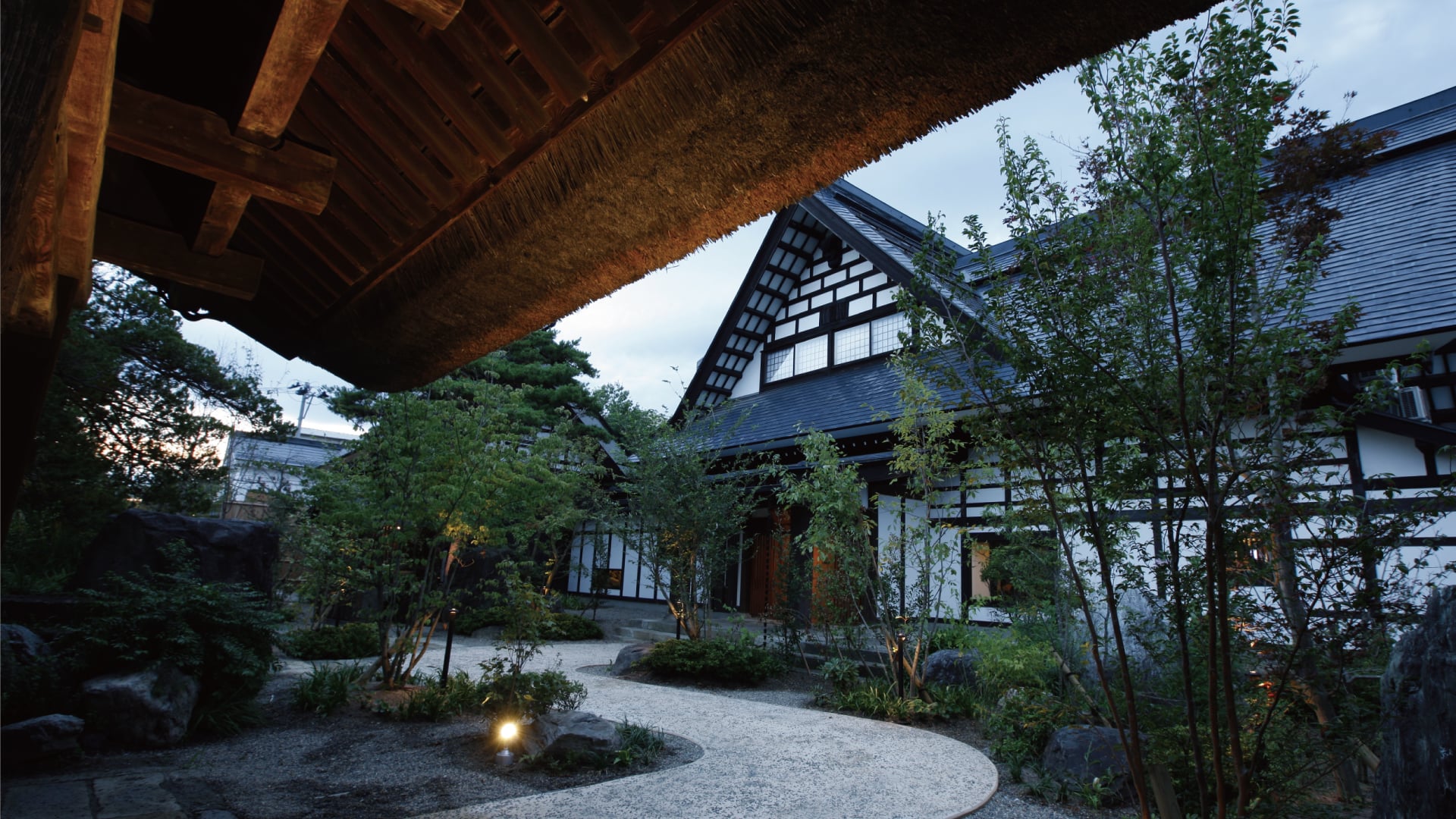 山形座 瀧波 — 山形・赤湯温泉 · 茅葺き屋根の庄屋屋敷を移築した本館と庭の夕景