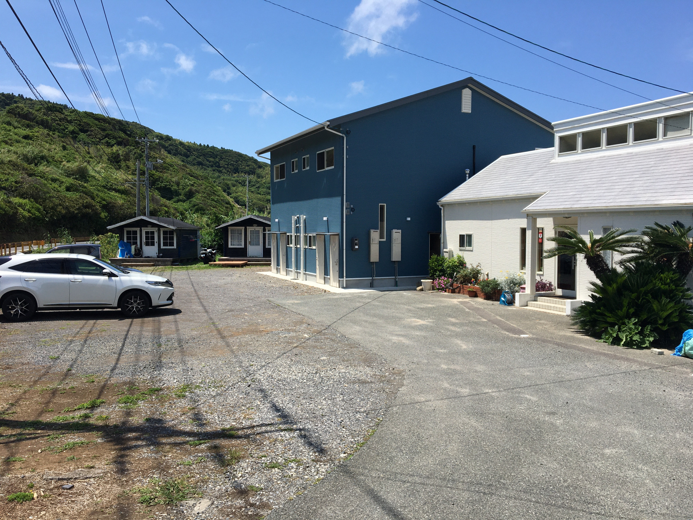 シーブリーズ⁺ 1987 — 長門市油谷・大浜海岸 · 波打ち際に建つ青い木造のビーチコテージとカフェ