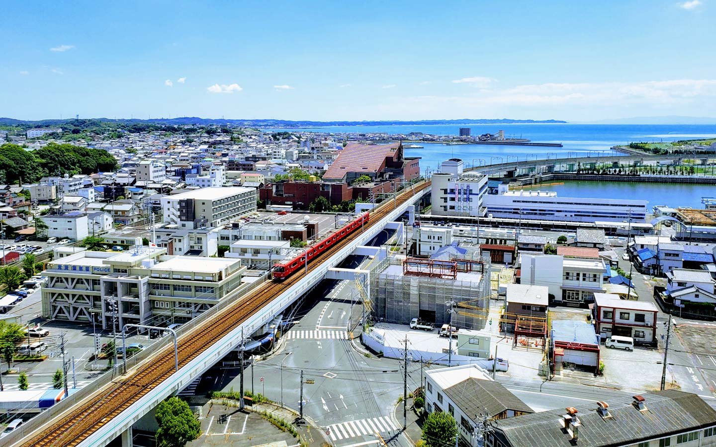 スプリングサニーホテル 名古屋常滑駅前 — 常滑市・常滑駅前 · 客室から望む名鉄常滑線の高架と常滑のまち、奥に伊勢湾
