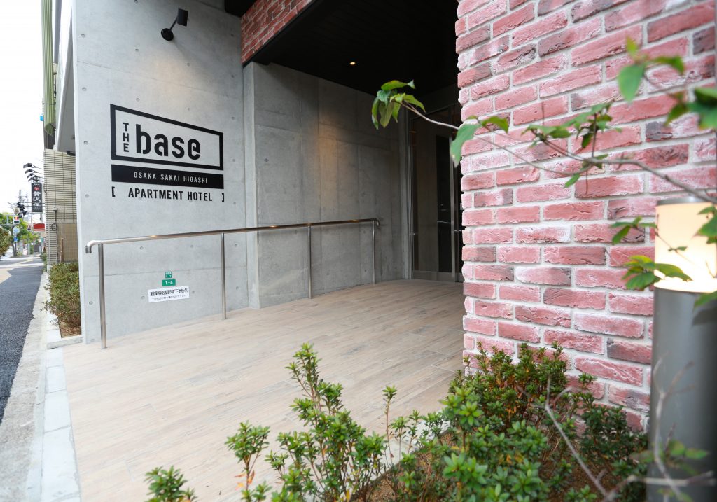 ザ・ベース・堺東・アパートメントホテル — 堺市堺区南花田口町 · コンクリートと煉瓦の外構、全54室のアパートメント型ホテル入口