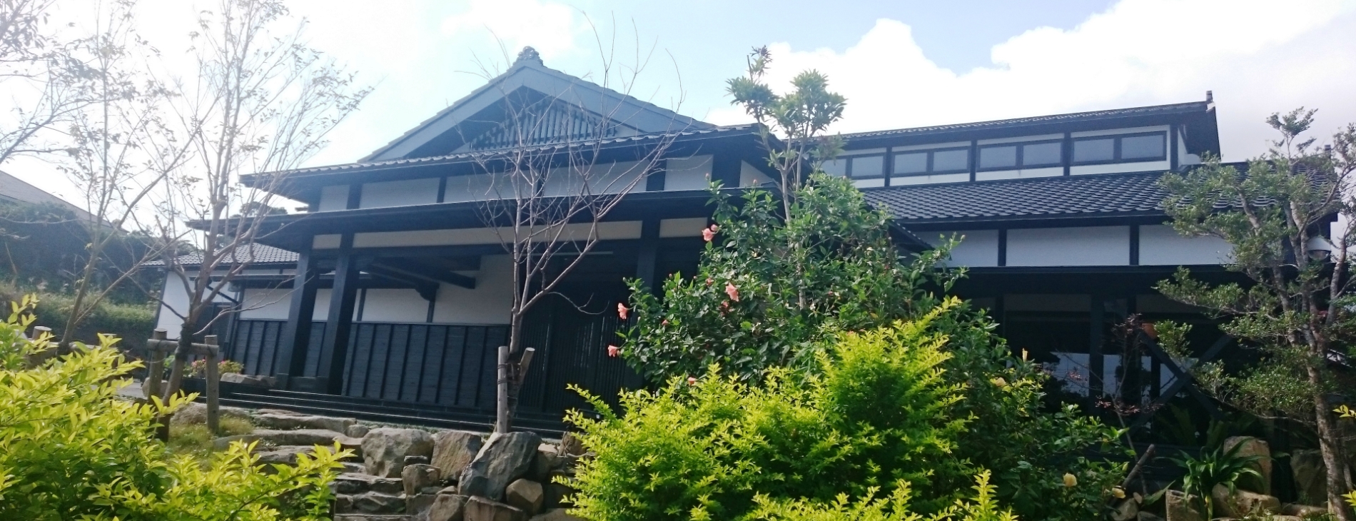 縄文の宿 まんてん — 屋久島空港前・天然温泉と屋久杉の梁を持つ二階建て木造外観