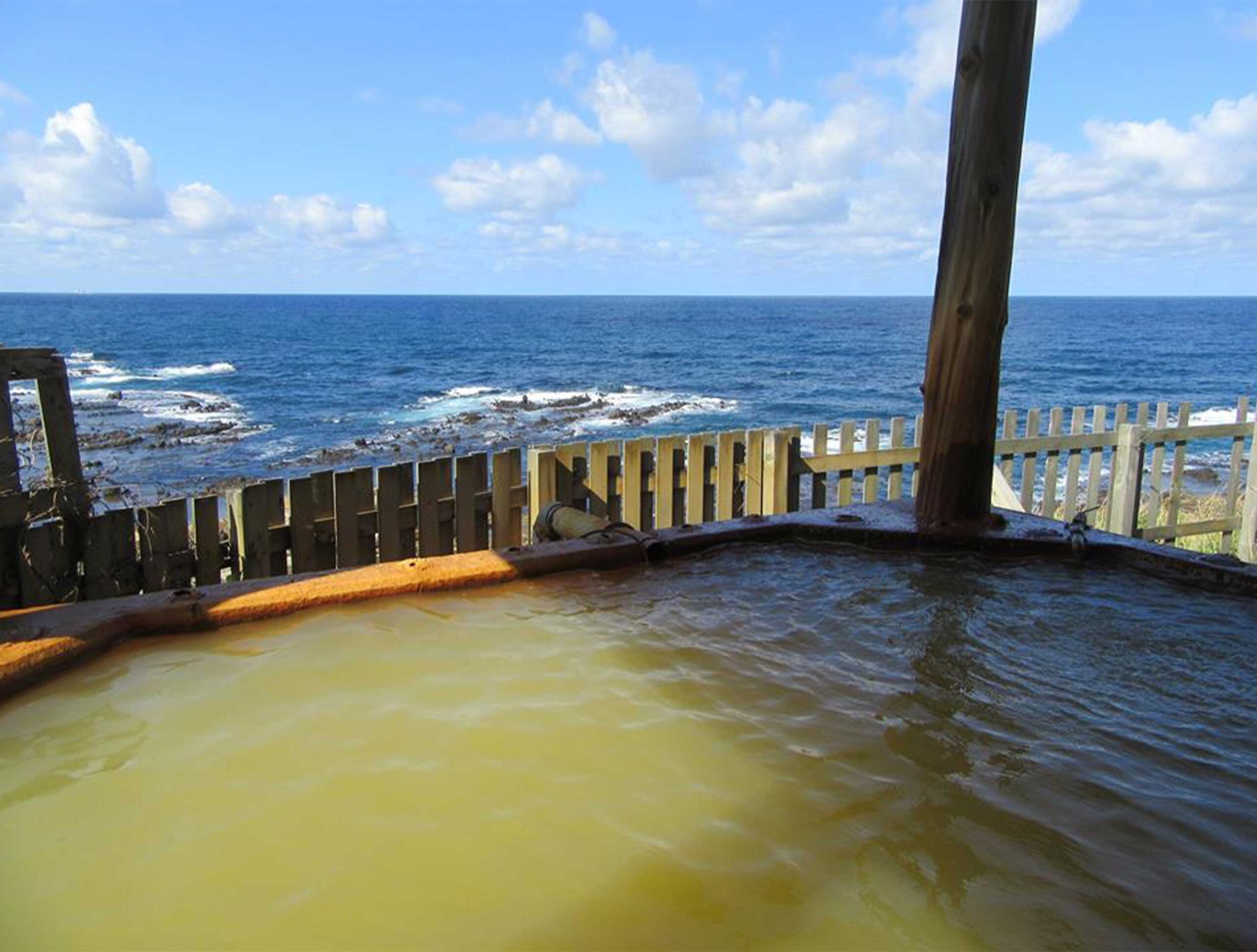 黄金崎不老ふ死温泉 海辺の露天風呂 — 空気に触れて赤褐色に変わった含鉄泉と日本海の岩礁