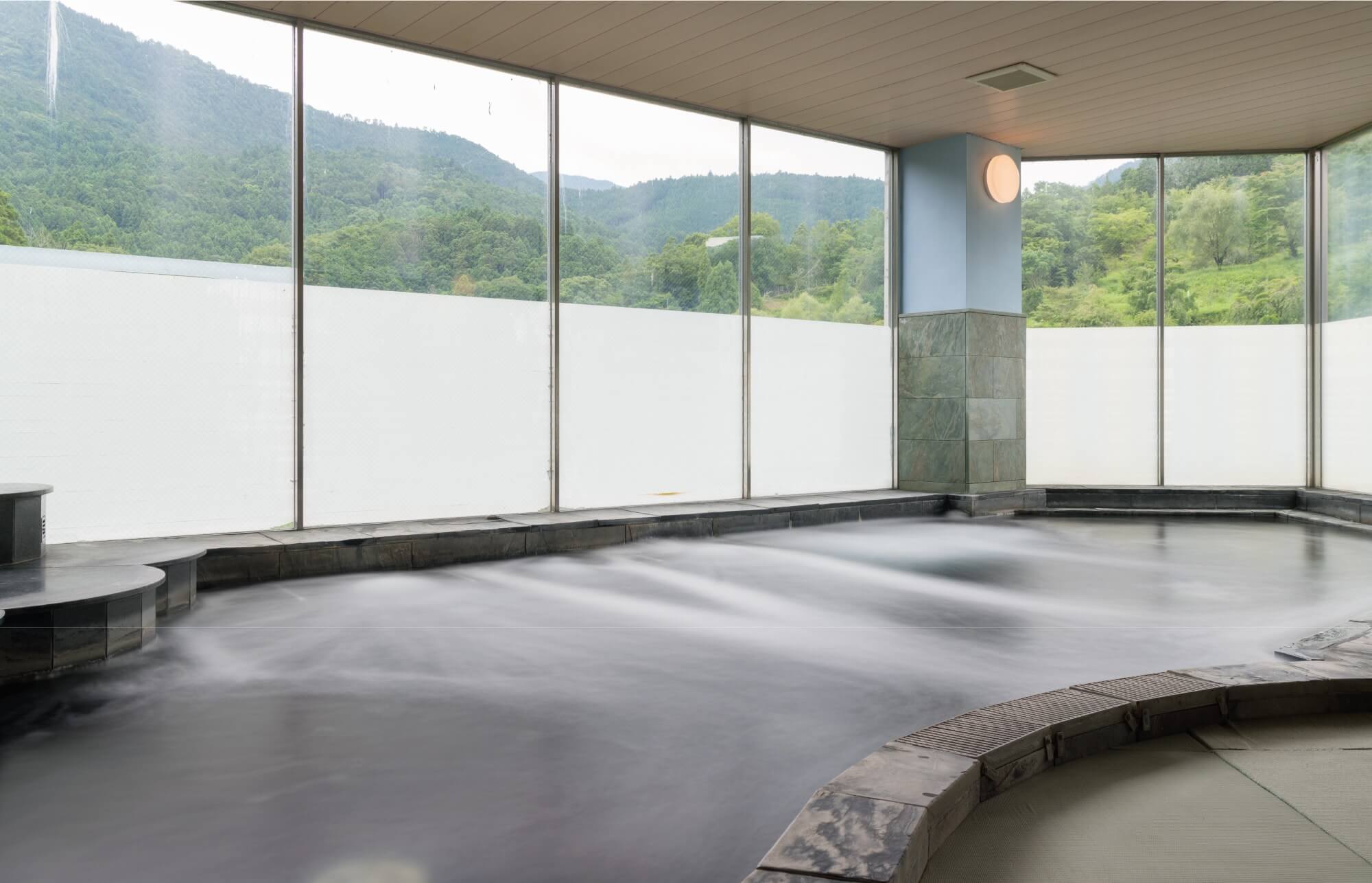 神山温泉 ホテル四季の里＆いやしの湯 — 徳島県名西郡神山町神領 · 里山を望む大浴場、脱衣所から浴場まで畳敷き