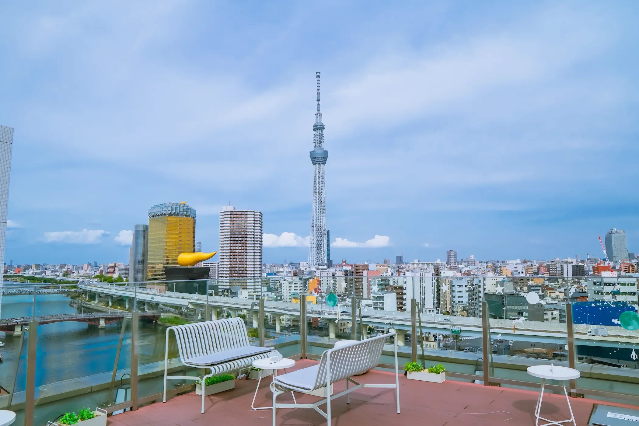 KOKO HOTEL 浅草駒形 — 台東区駒形 · 屋上テラスから望む隅田川と東京スカイツリー、ベンチを配した眺望空間