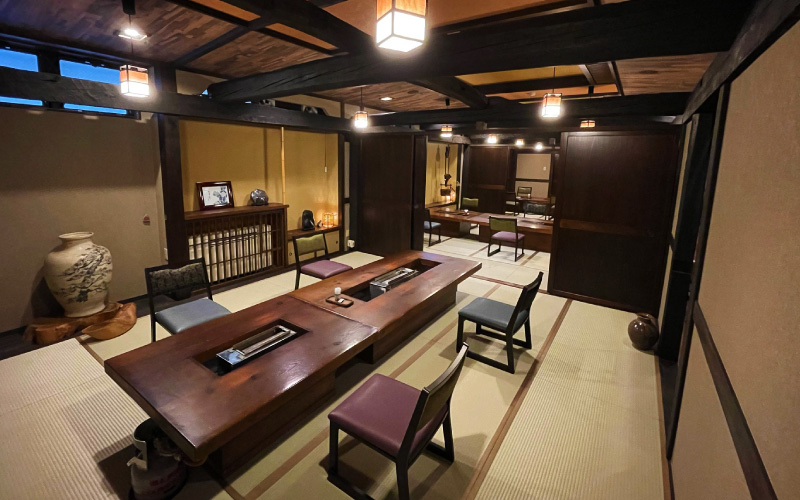 元湯 孫九郎 — 岐阜・奥飛騨福地温泉 · 天領館の食事処に並ぶ炉端風テーブルと畳敷きの座席