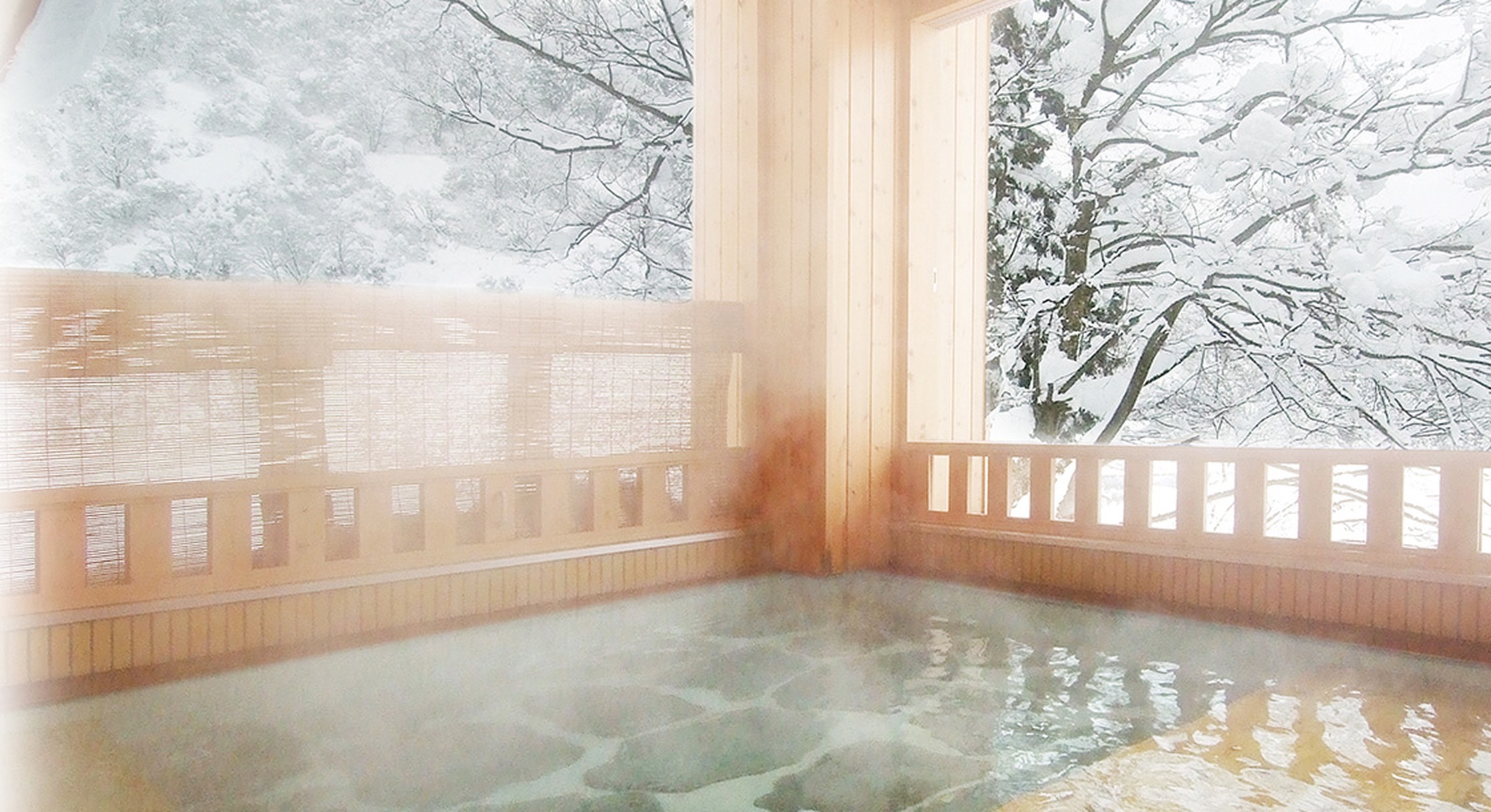 雪国の宿 高半 — 新潟県湯沢町・越後湯沢の高台 · 窓の外に雪をかぶった木立が広がる源泉かけ流しの浴場