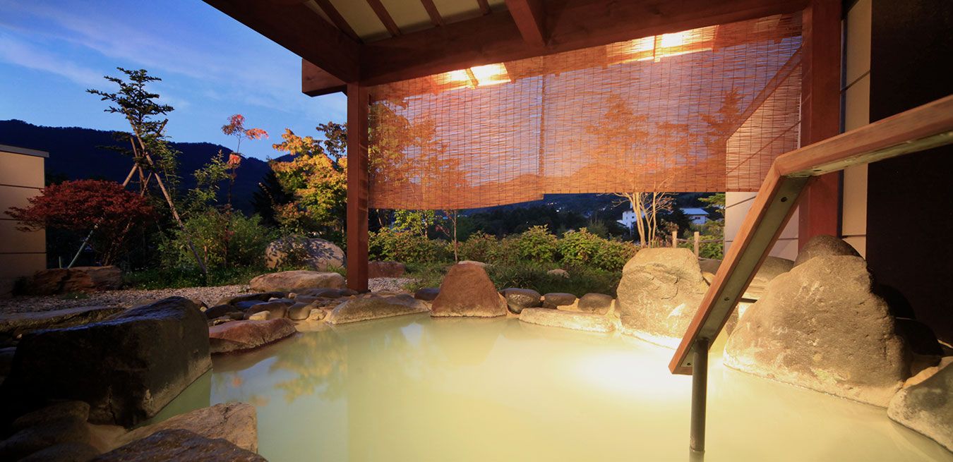 蔵王四季のホテル — 山形県・蔵王温泉 · 温泉棟「離れ湯百八歩」の乳白色の露天風呂と山の夕景
