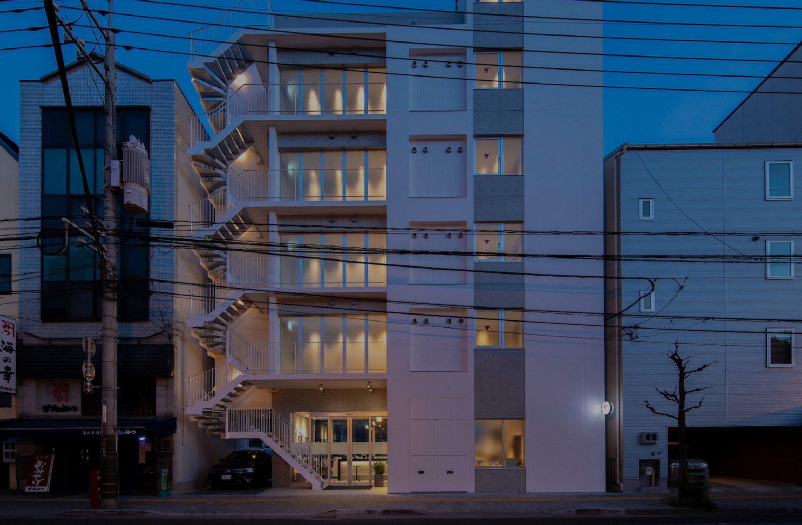 urashima INN -GANGI- — 尾道・土堂 · 海岸通りに面した全16室の小型ホテル外観、暮れなずむ時刻の外階段と灯り