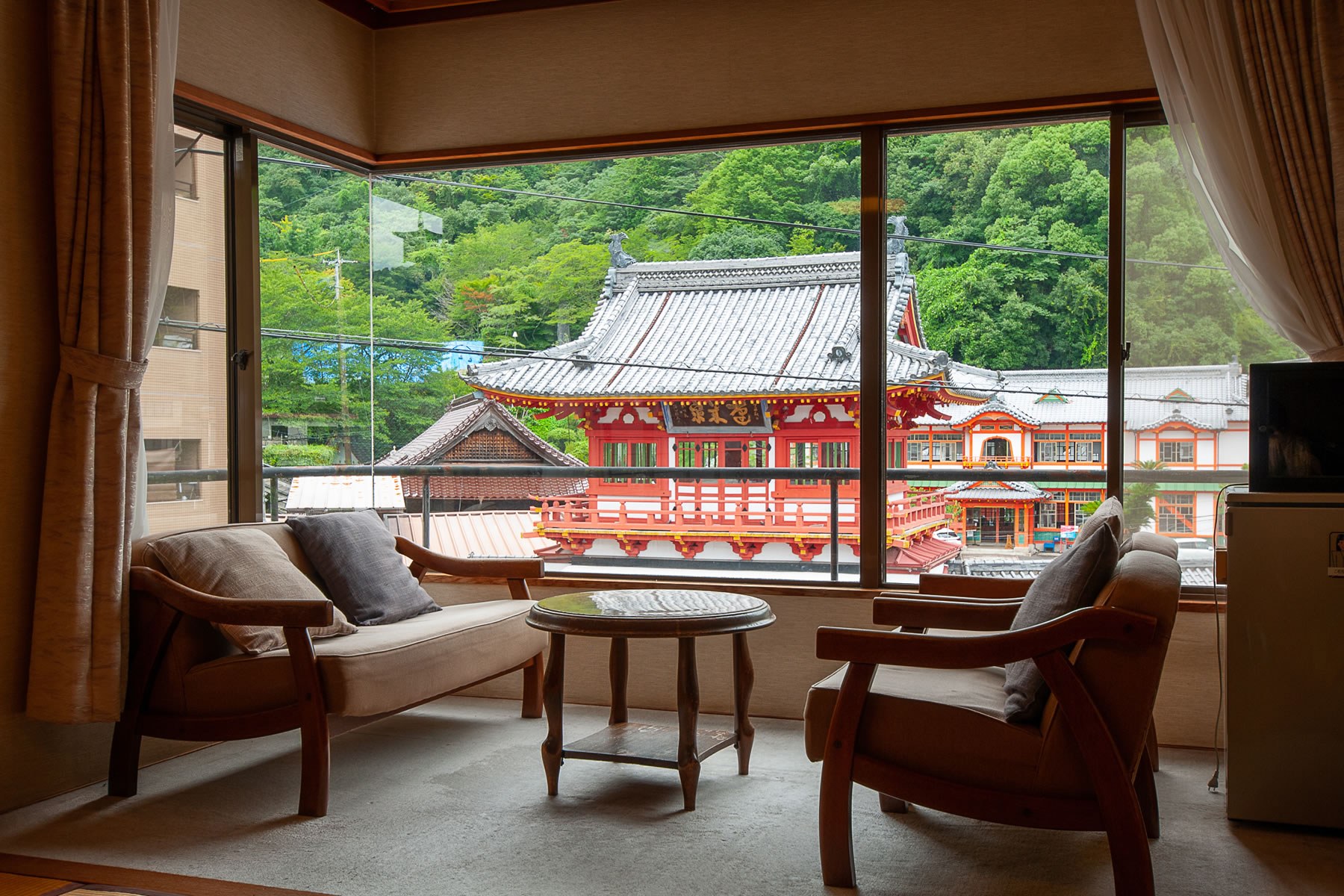 湯元荘 東洋館 — 佐賀県武雄市・武雄温泉 · 客室の窓いっぱいに朱塗りの楼門と新館を望む