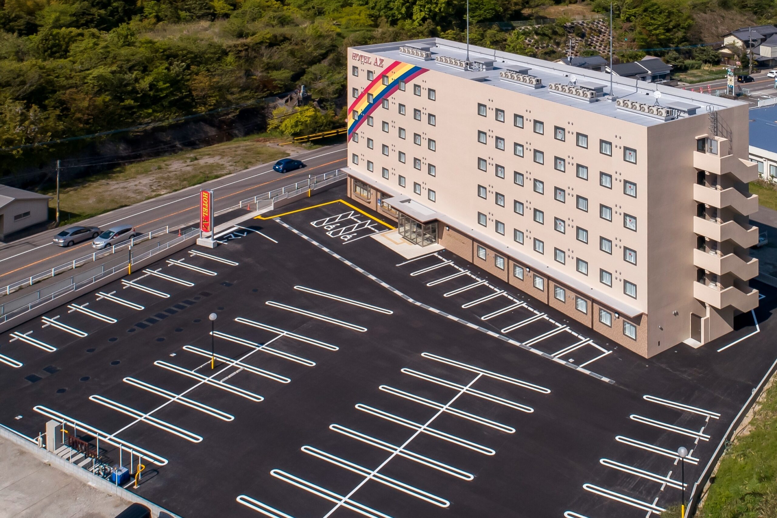 HOTEL AZ 徳島小松島店 — 小松島市金磯町 · 広い平面駐車場を備えた2021年開業の158室のホテル外観