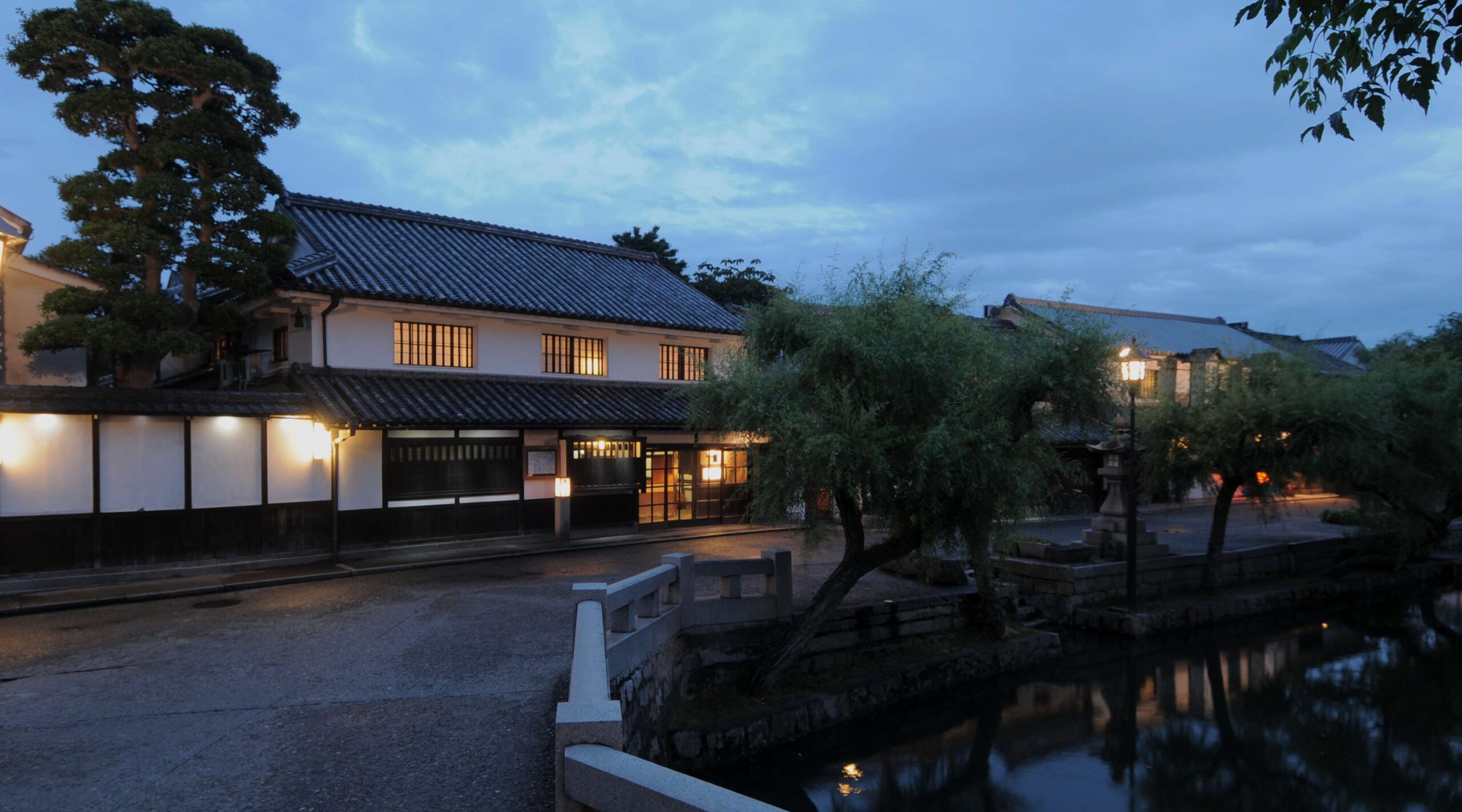 旅館くらしき — 倉敷市本町・中橋のたもと · 砂糖問屋の母屋と蔵を再生した料理旅館の夕景