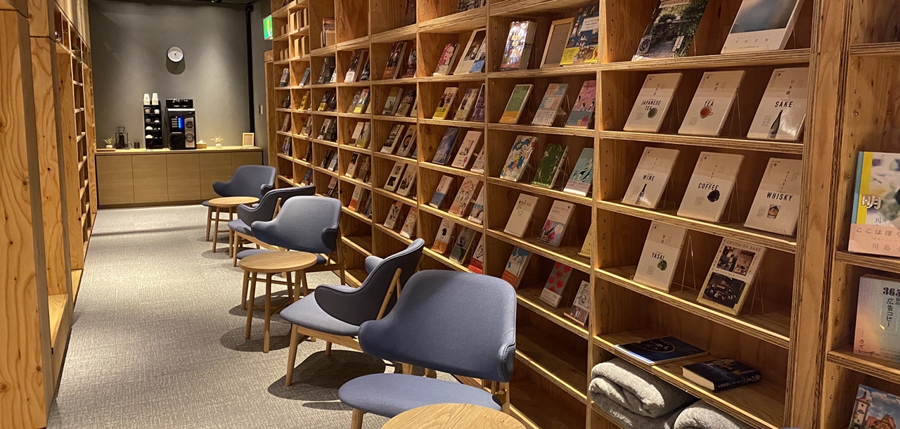 ホテル ナトゥールヴァルト富良野 — 館内のライブラリーラウンジ · 壁一面の書棚と一人掛けチェアが並ぶ静かな空間