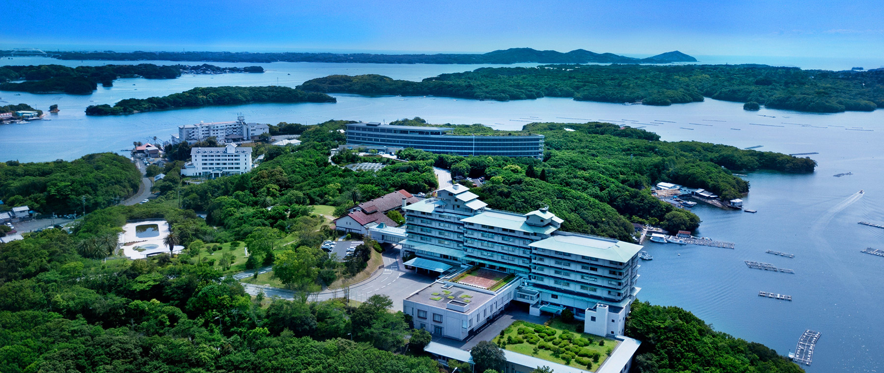 志摩観光ホテル — 三重県志摩市・賢島 · 英虞湾に突き出す岬に建つザ クラシックとザ ベイスイートの空撮