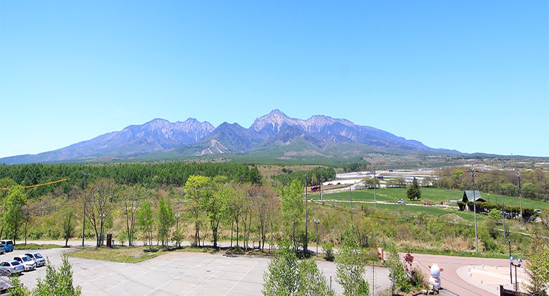 八ヶ岳グレイスホテル — 長野県南牧村・野辺山高原 · 客室から望む夏の八ヶ岳連峰と高原の森