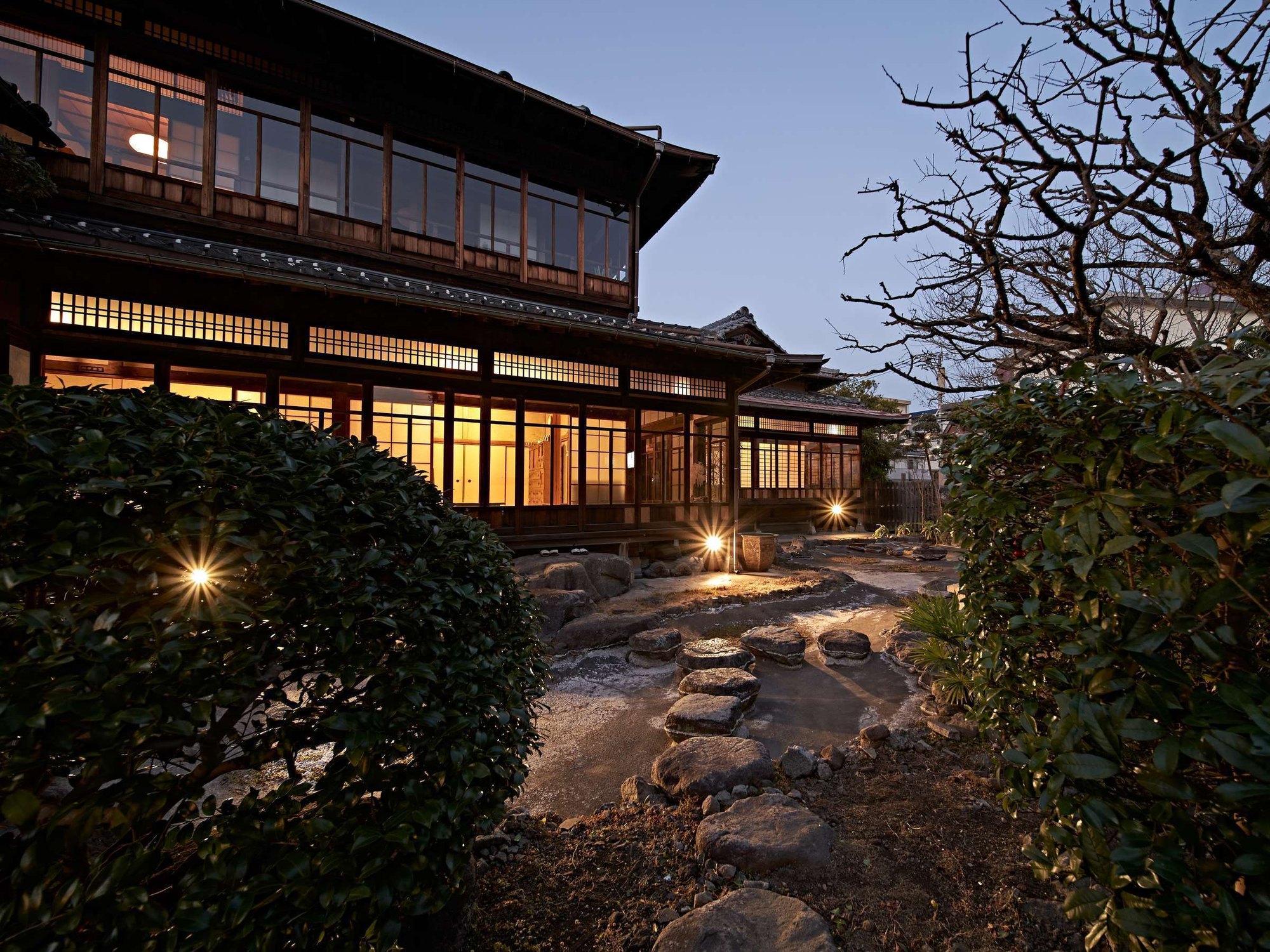 山田別荘 — 別府市北浜 · 夕暮れに灯りがともる1930年築の木造別荘建築と庭