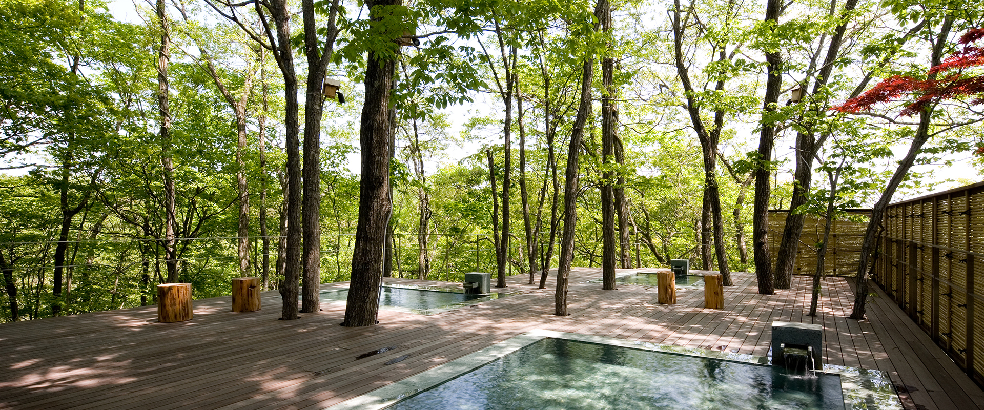 竹泉荘 Mt.Zao Onsen Resort & Spa — 宮城県蔵王町・遠刈田温泉 · 木立の中にウッドデッキと石の湯船を配した露天風呂
