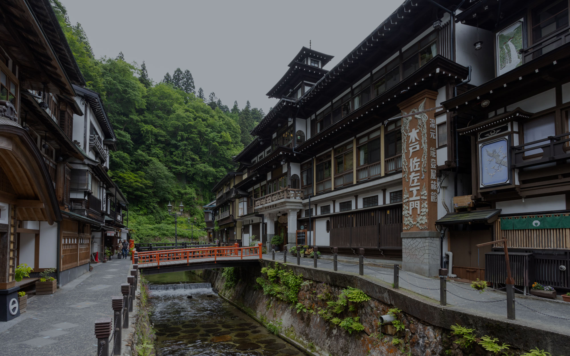 能登屋旅館 — 尾花沢市銀山温泉 · 銀山川沿いに立つ明治25年創業の木造三階建ての外観