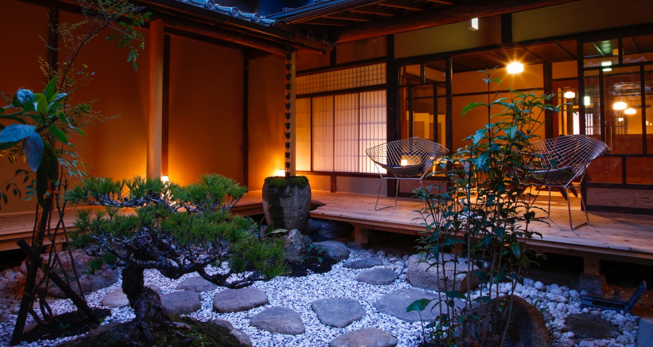 古民家の宿 加里屋旅館Q — 兵庫県赤穂市加里屋 · 灯りを落とした坪庭と縁側、往時の梁を残す館内