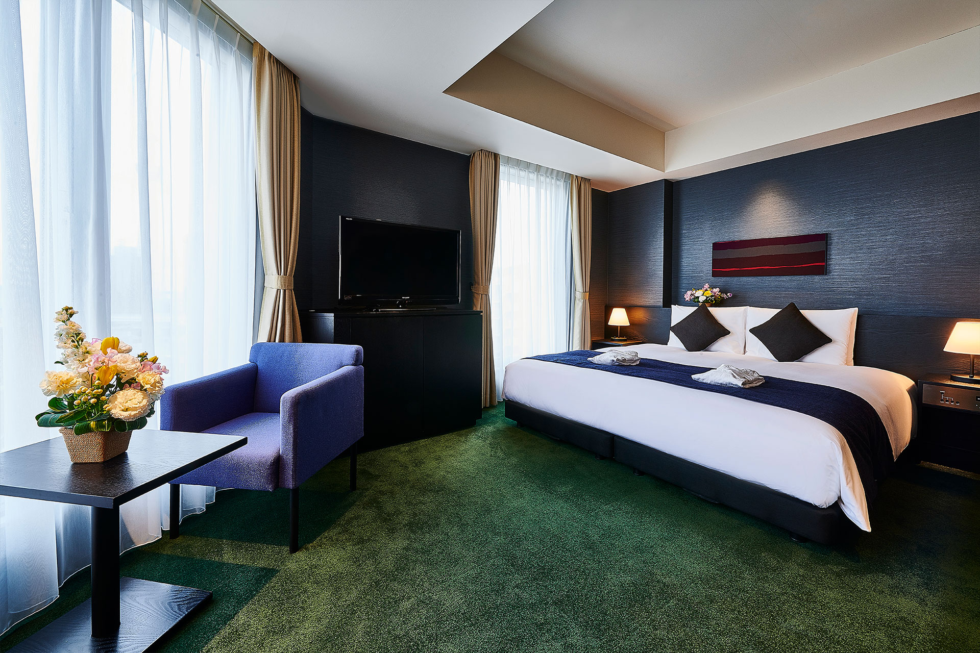 THE GATE HOTEL 雷門 by HULIC — 客室 · 深いネイビーの壁面と緑のカーペットで構成された眺望重視の一室