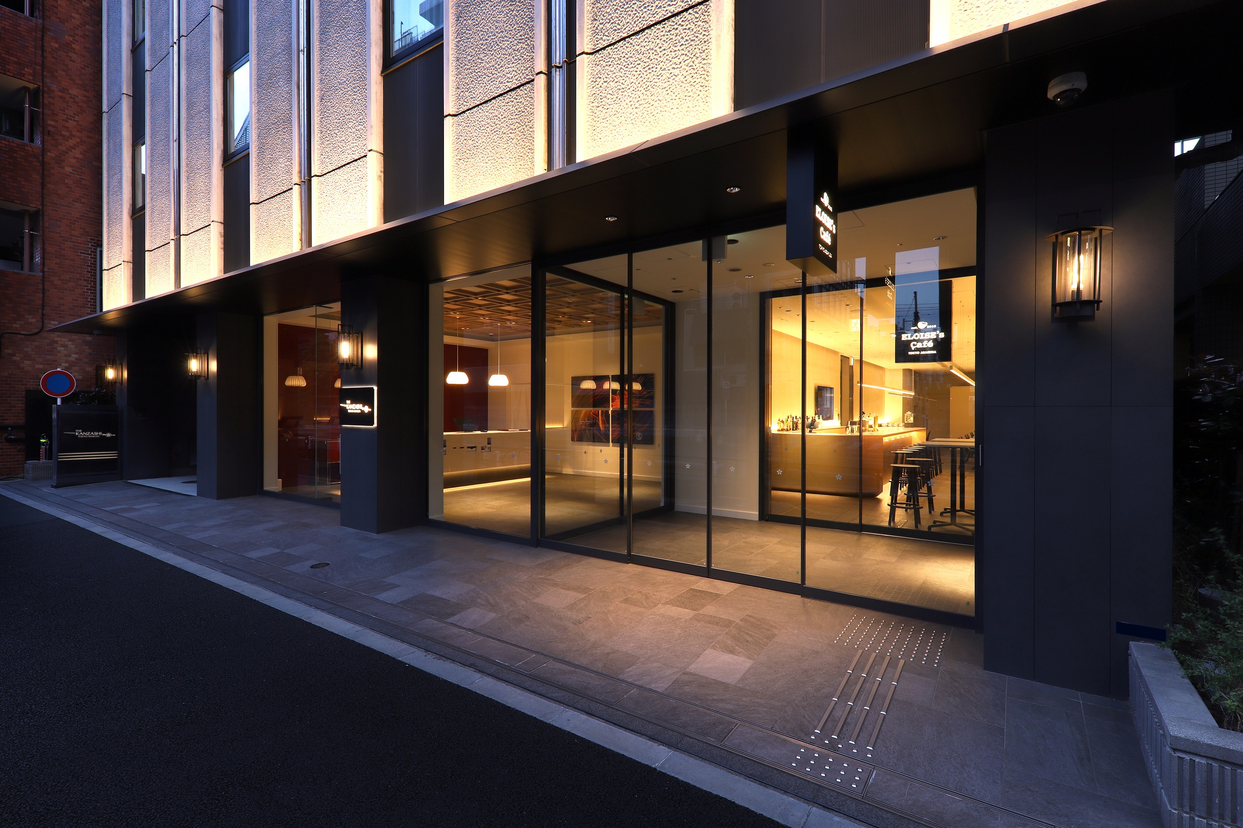 THE KANZASHI TOKYO ASAKUSA — 外観 · 夜の浅草二丁目に灯るエントランスと1階カフェ、こたたき仕上げの外壁