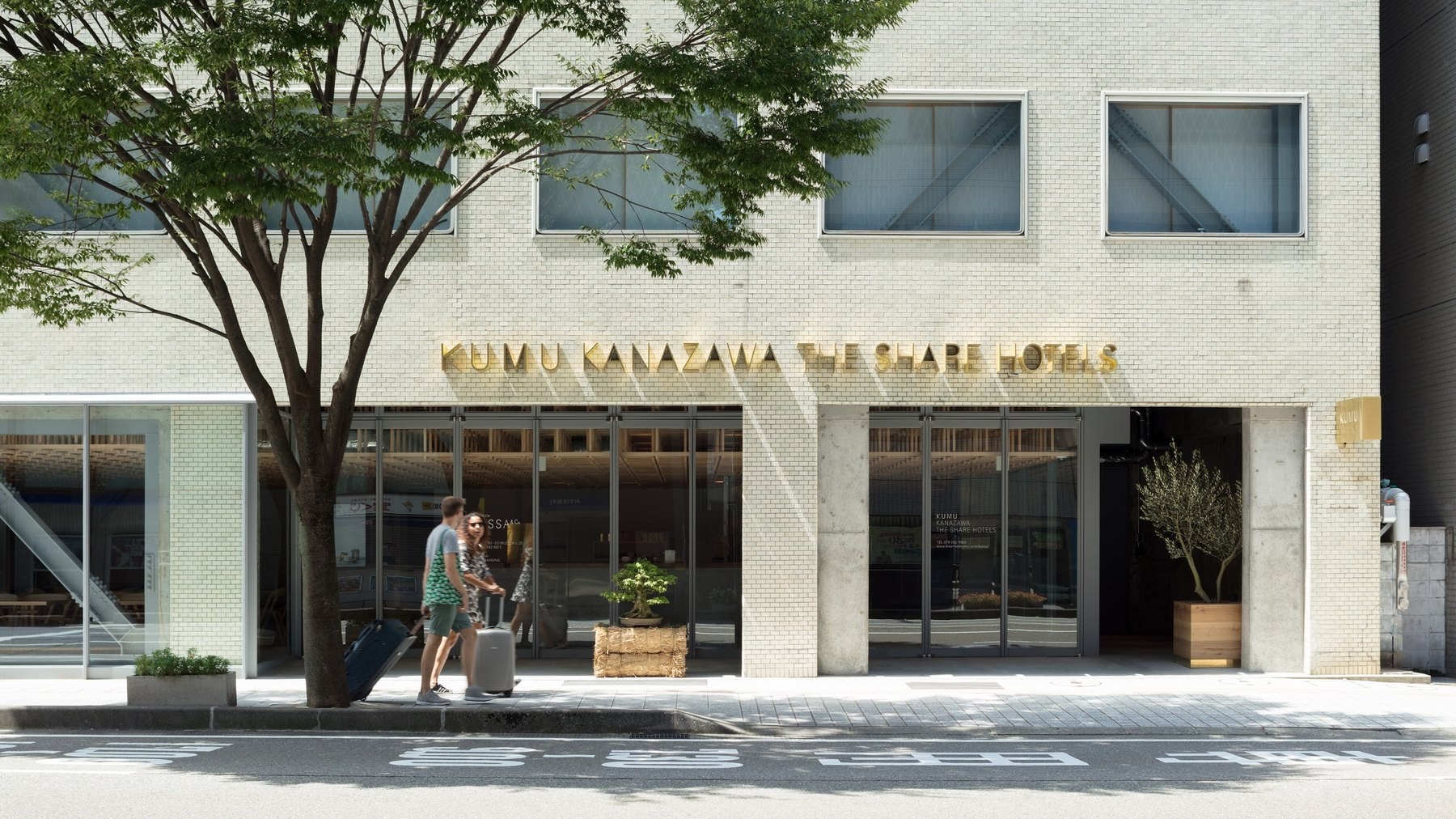 KUMU 金沢 by THE SHARE HOTELS — 金沢市上堤町 · 白タイルの外観と、1階にティーサロンを開く街路側ファサード