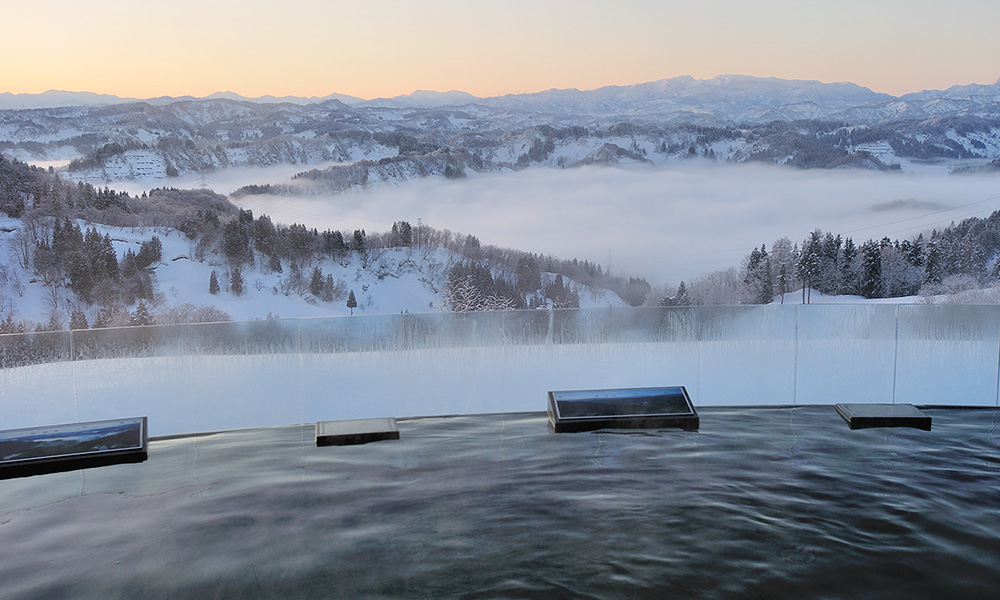 まつだい芝峠温泉 雲海 — 新潟県十日町市蓬平 · 冬の露天風呂から望む雪をかぶった山並みと谷を埋める雲海