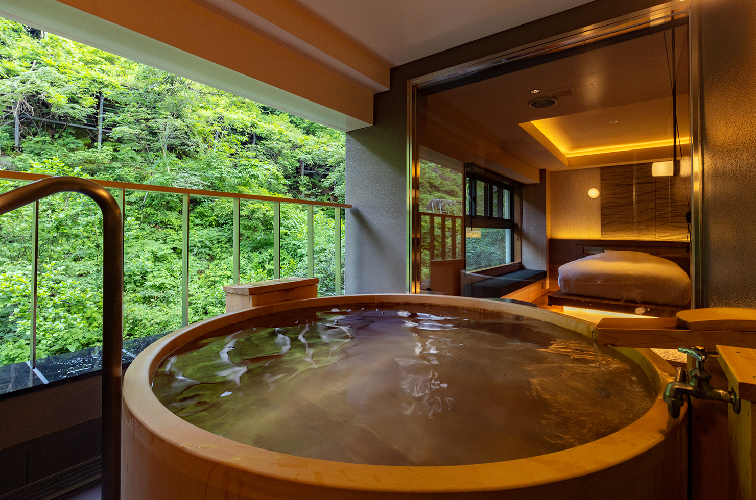 酒の宿 玉城屋 — 新潟県十日町市松之山湯本 · 源泉かけ流しの露天風呂を備えた客室、窓の外は松之山の谷あい
