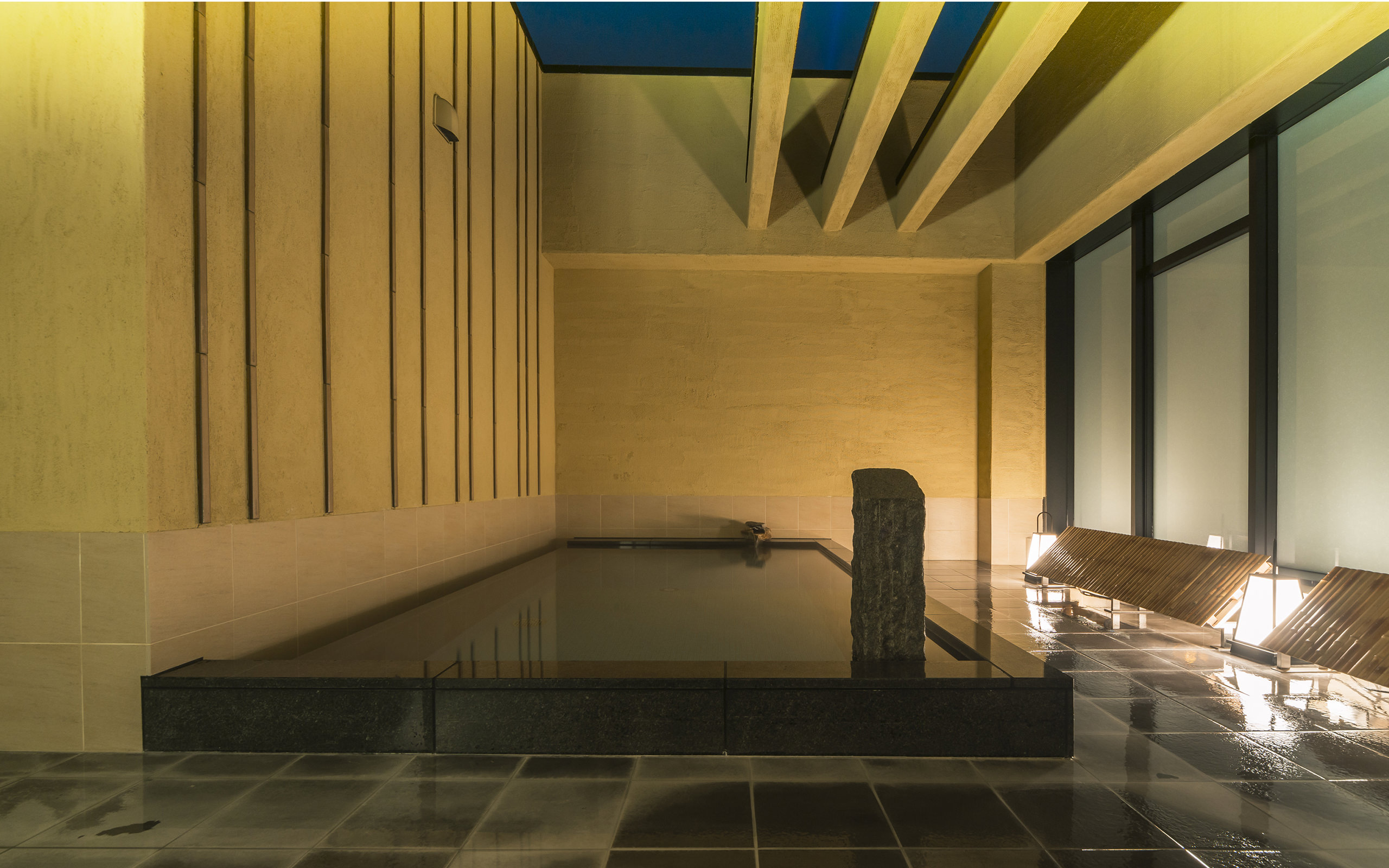 カンデオホテルズ福岡天神 — 福岡市中央区渡辺通 · 最上階のスカイスパ、照明に照らされた展望露天風呂