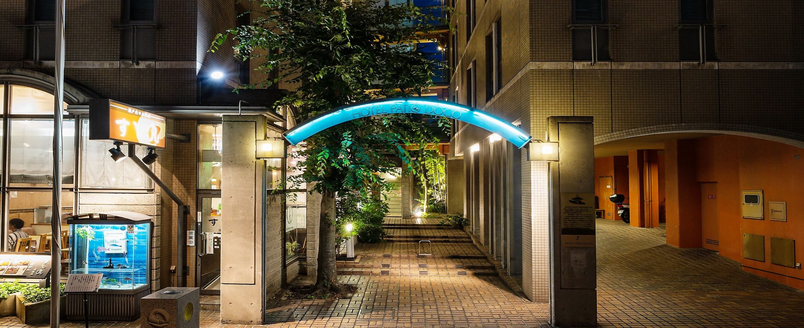 ホテル パティオ・ドウゴ — 松山市道後湯之町 · 道後温泉本館前に建つホテルの夜の中庭とエントランス