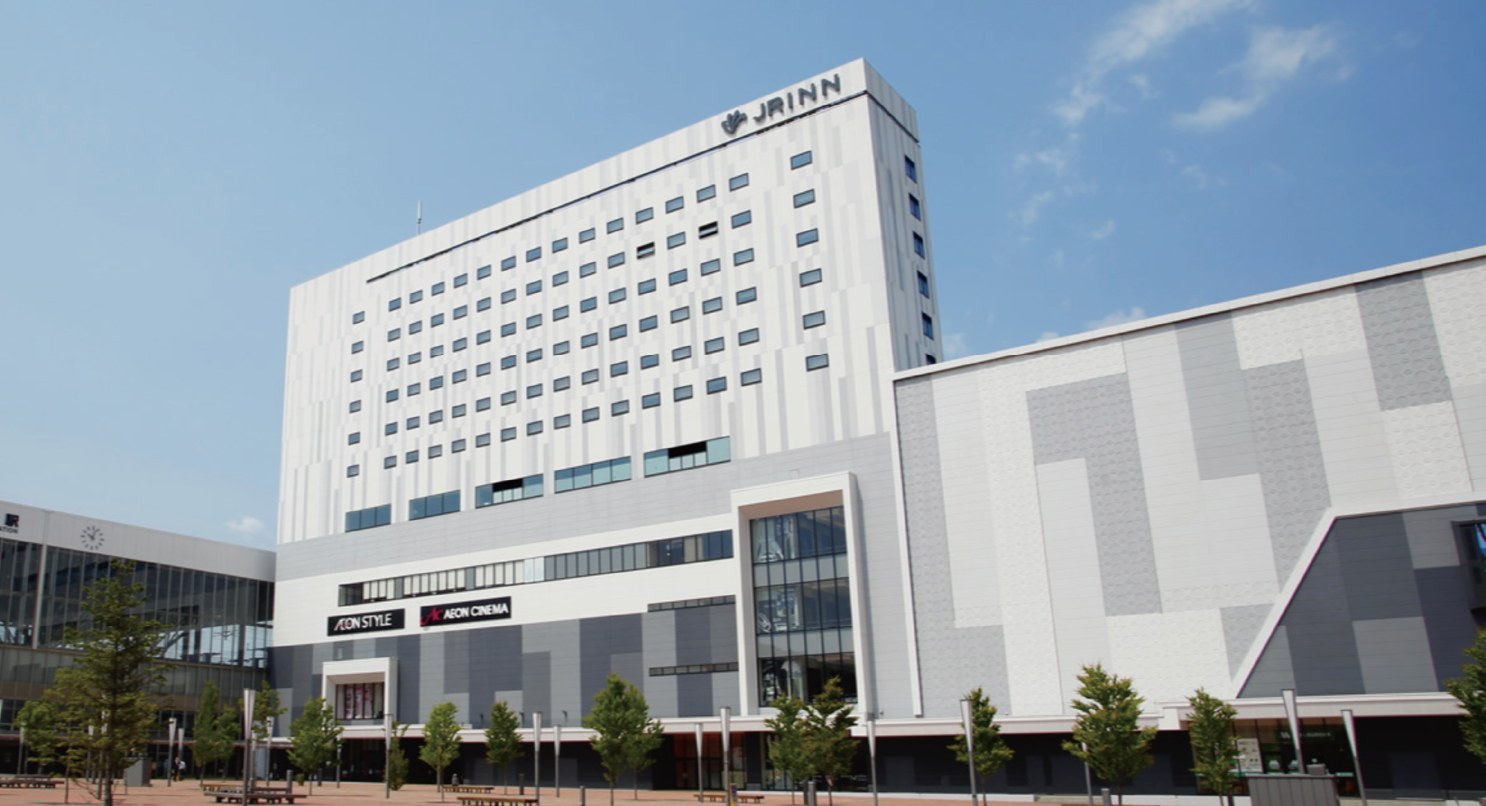 JRイン旭川 — 北海道旭川市・JR旭川駅前 · 駅前広場に面した商業施設の上階に入る宿泊特化型ホテルの外観