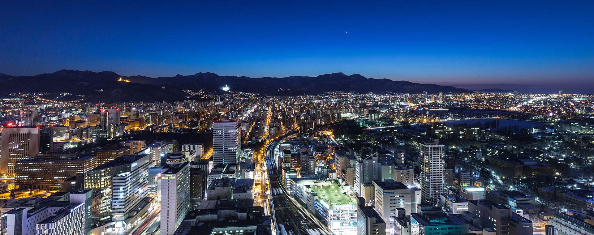 JRタワーホテル日航札幌 — 札幌駅直結 · 公式サイトに掲載された札幌市街と山並みを望む冬の夜景