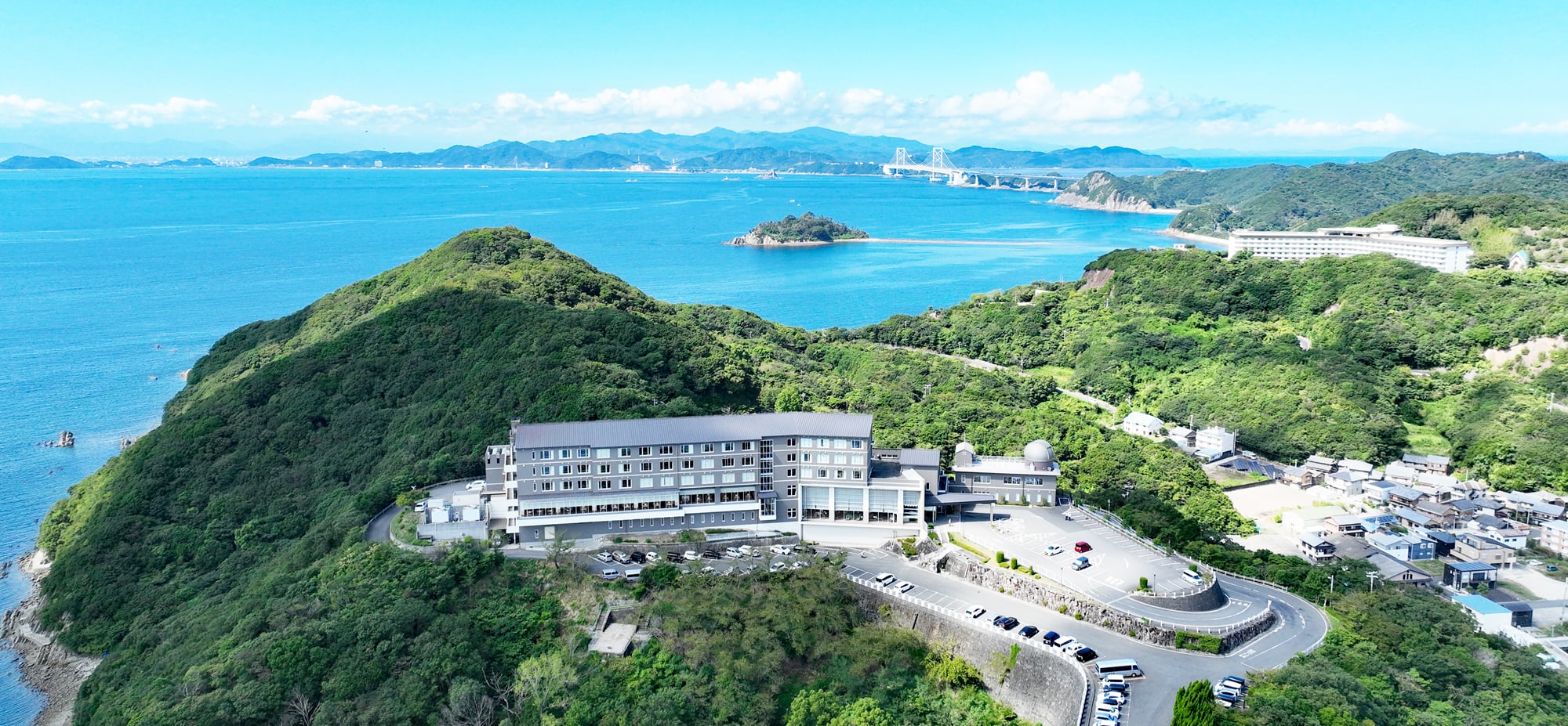 休暇村 南淡路 — 南あわじ市・福良 · 岬の上に建つ本館と天文台ドーム、奥に福良湾と大鳴門橋