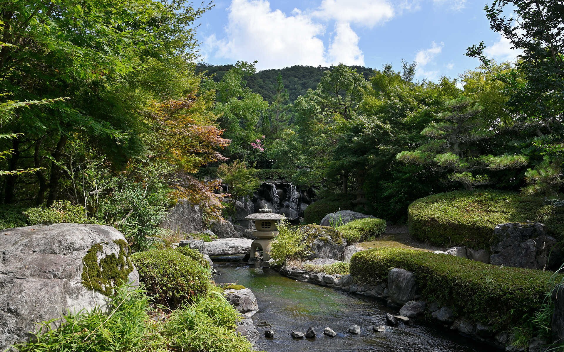 三朝館 — 三朝温泉 · 池と石組み、刈り込みが続く約1,000坪の日本庭園