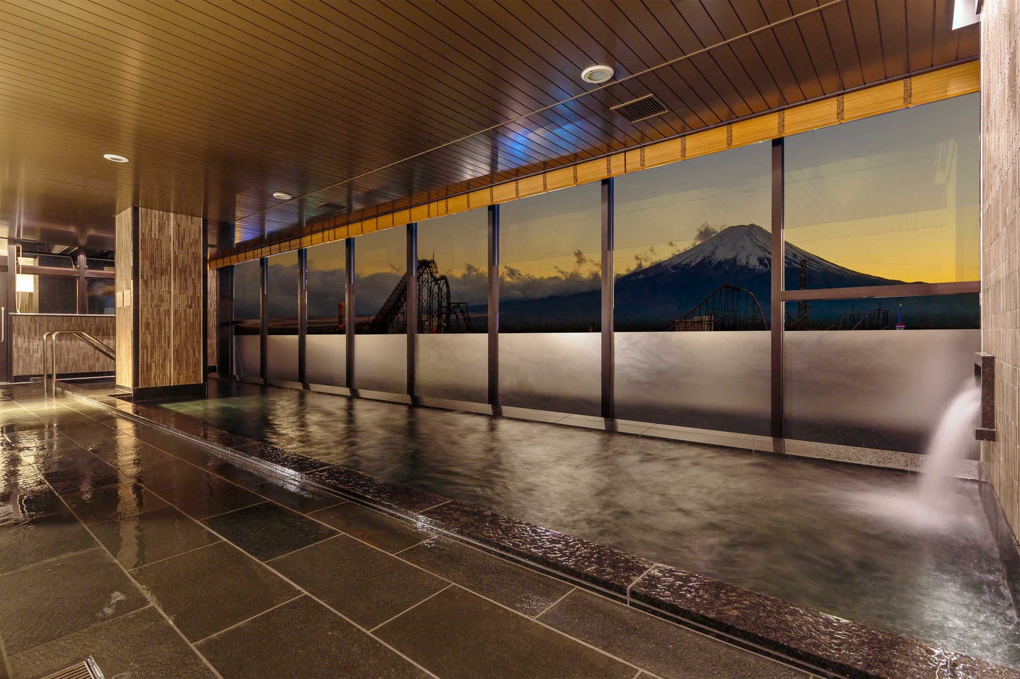 ホテルマイステイズ富士山 展望温泉 — 山梨県富士吉田市 · 最上階の天然温泉展望大浴場、窓越しに夕景の富士山