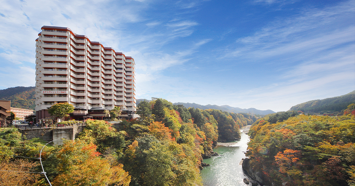 ホテルサンシャイン鬼怒川 — 鬼怒川温泉 · 紅葉の鬼怒川渓谷沿いに建つ温泉ホテルの外観