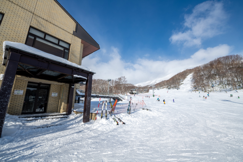 ニセコノーザンリゾート・アンヌプリ — 北海道ニセコ町 · 雪のゲレンデに面した建物と冬の青空