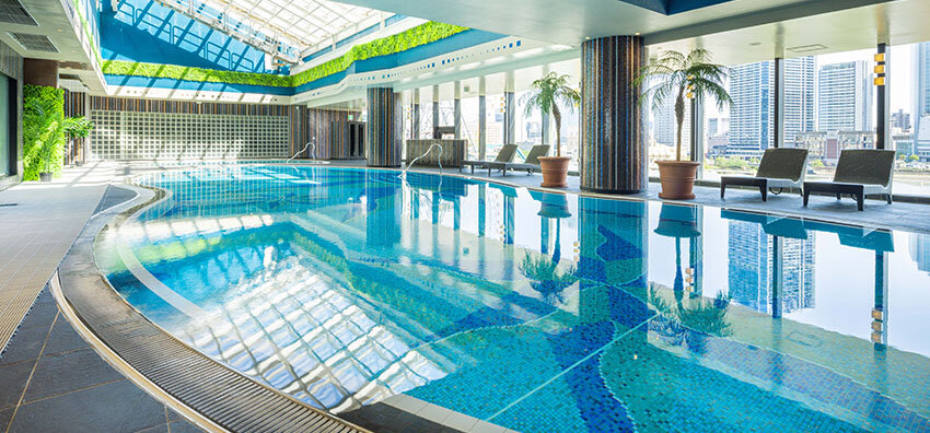 横浜ベイホテル東急 — みなとみらい · 全天候型のプールエリア「Blue Oasis」と窓越しの高層ビル群