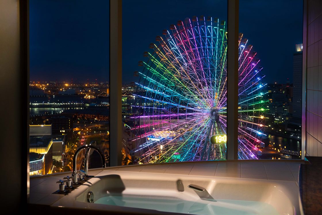 横浜ベイホテル東急 — ラグジュアリー オーシャンツイン ベイビュー · バスタブ越しに大観覧車の夜景を望むバスルーム