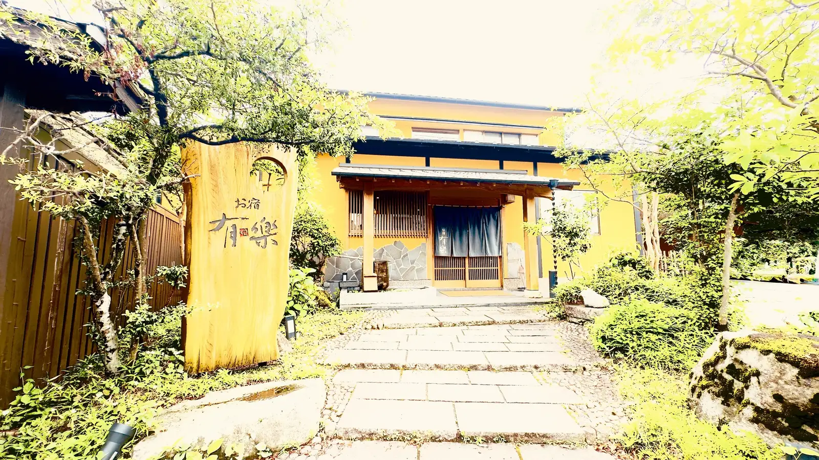 お宿 有楽 — 由布院・辻馬車通り · 木の看板と暖簾が掛かる母家の玄関